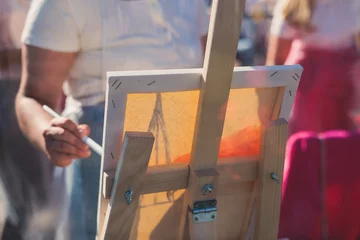 Fototapeten Process of drawing, group class of talented students with painting easels and canvases during lesson of watercolour painting outdoors, drawing class for adult artists in art school © tsuguliev