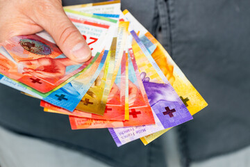 Switzerland money, a bundle of francs held in hand financial concept, close up
