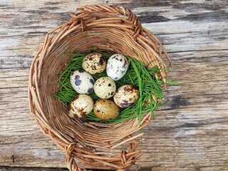 quail eggs in a basket on wooden background