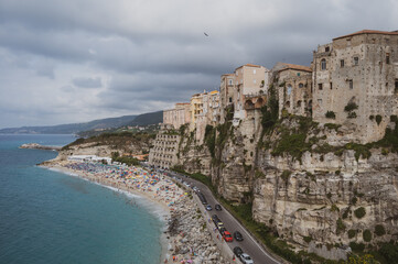 Fototapeta na wymiar Italy, August 2023: panoramic view of the orgo of Tropea in Calabria. The town stands on a rock spur and overlooks a transparent Caribbean sea with many tourists