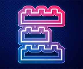 Glowing neon line Toy building block bricks for children icon isolated on blue background. Vector