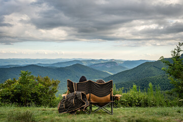 Couple sitting overlooking the Blue Ridge Mountains, Looking Glass Rock near Brevard, North Carolina, USA