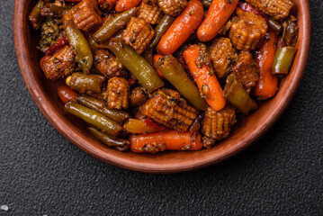 Mix of vegetables corn, carrots, peppers, broccoli, onions in teriyaki sauce on a ceramic plate