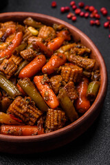 Mix of vegetables corn, carrots, peppers, broccoli, onions in teriyaki sauce on a ceramic plate