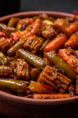 Mix of vegetables corn, carrots, peppers, broccoli, onions in teriyaki sauce on a ceramic plate