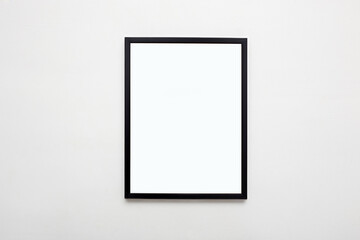 black picture frame on white wall. Stylish modern photoframe