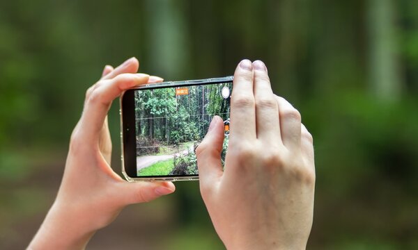 Hands holding phone, taking photo, recording horizontal video