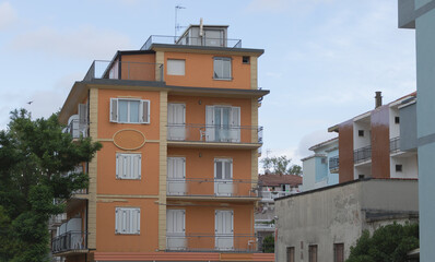 Apartment building in orange color in the city of Rimini, Italy