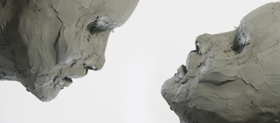 Two clay faces on a white background. Portrait, sketch without eyes. Artwork in process of...