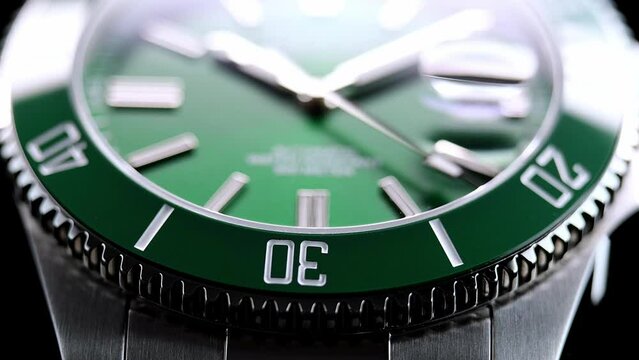 Stylish Luxury Man Wrist Watch With Moving Hand And Multiple Dials. Men's watch in metal with sapphire crystal. Closeup view of rotating watch, running second arrow. green dial. Cyclops watch