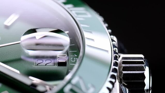 Stylish Luxury Man Wrist Watch With Moving Hand And Multiple Dials. Men's watch in metal with sapphire crystal. Closeup view of rotating watch, running second arrow. green dial. Cyclops watch