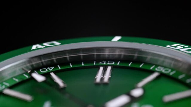 Stylish Luxury Man Wrist Watch With Moving Hand And Multiple Dials. Men's watch in metal with sapphire crystal. Closeup view of rotating watch, running second arrow. green dial. Cyclops watch