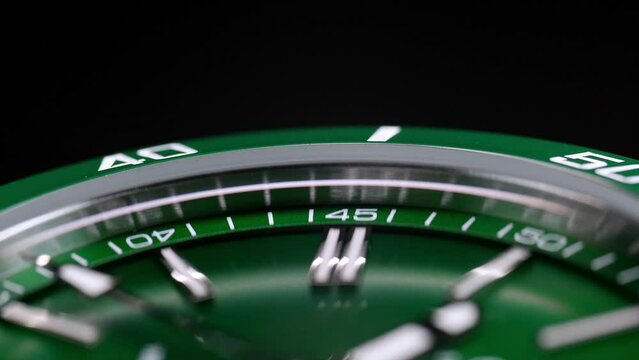 Stylish Luxury Man Wrist Watch With Moving Hand And Multiple Dials. Men's watch in metal with sapphire crystal. Closeup view of rotating watch, running second arrow. green dial. Cyclops watch
