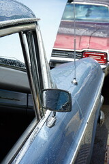 Sechszylinder Luxus Limousine der Fünfzigerjahre in Blau Metallic mit offener Motorhaube im Regen...
