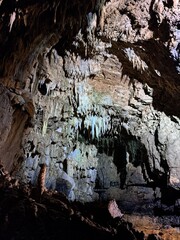 grotta con stalattiti e stalagmiti, attraversata dal fiume