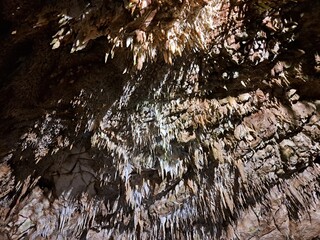grotta con stalattiti e stalagmiti, attraversata dal fiume