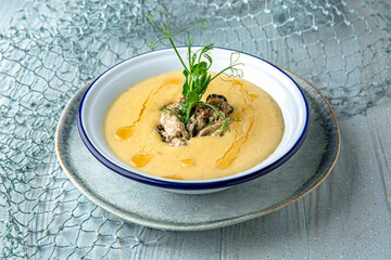 Creamy chicken and mushroom soup on a blue background. Mediterranean Kitchen. Sea mood menu.