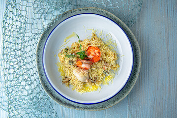 Risotto with parmesan and seafood on a blue background. Mediterranean Kitchen. Sea mood menu.
