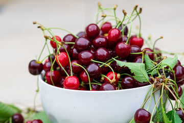 Freshly picked leaf cherries in white bowl