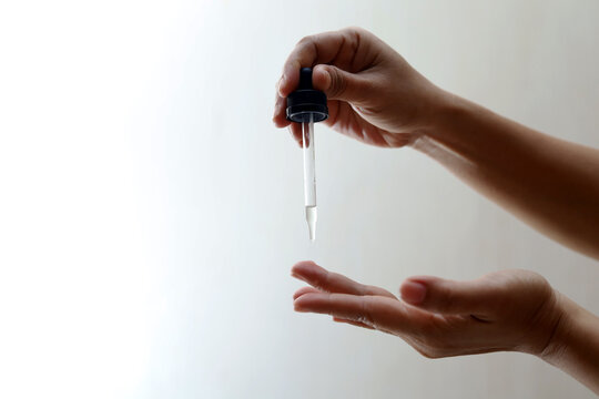 Women's hands hold pipette with cosmetic serum 