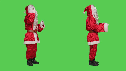 Santa claus fighting with people, having argument over full body greenscreen. Young adult portraying father christmas in seasonal red costume, conflict during winter holiday event.