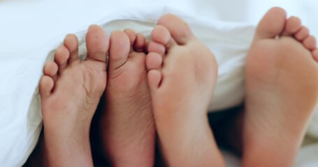 Couple, relax and feet in bed together on holiday, vacation or sleeping in the morning with love, comfort and playful touching. People, care and playing with foot under blanket in bedroom or home