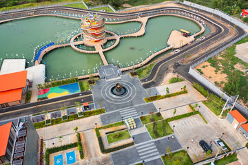 Aerial view of Kudwai Public Park Sisaket square landmark monument with residential neighborhood roofs. Urban housing development from above. Real estate in Isan urban city town, Thailand.