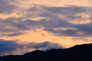 夜明け前、六甲の山並みと空。上空の雲が赤く染まり一日が始まる。早朝神戸市内から撮影