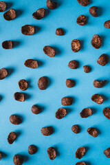 Top view of isolated chocolate corn flakes cereals on blue background. Breakfast concept.