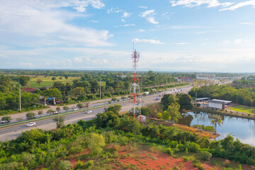 Aerial view of TV antenna in the middle of a city , red roofs on a housing community, vacant lots,...