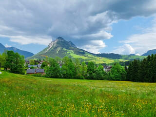 Fototapeta premium Summer austrian landscape with green meadows and impressive mountains, view from small alpine village Tauplitz, Styria region, Austria