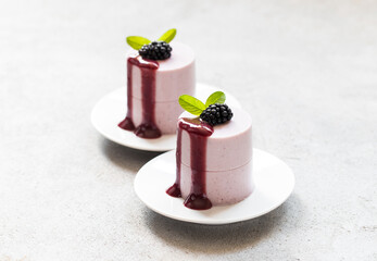 Vegan dessert. Blackberry cream jelly pudding, Panna Cotta cylindrical shape, with blueberry sauce....