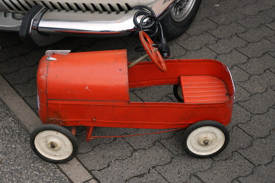 Altes Vintage Tretauto f&uuml;r Kinder in Rot mit Lenkrad und wei&szlig;en R&auml;dern auf dem Flohmarkt beim Oldtimertreffen Golden Oldies in Wettenberg Krofdorf-Gleiberg bei Gie&szlig;en in Hessen
