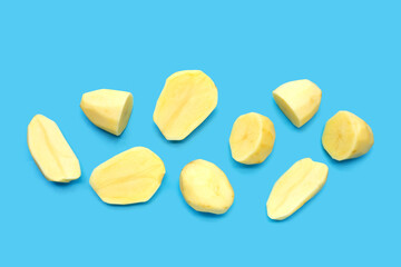 Raw peeled potatoes on blue background