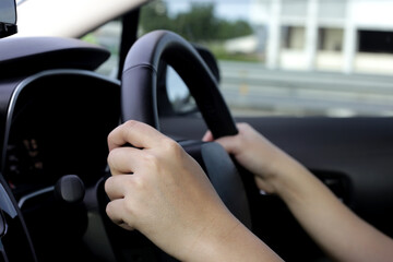 Naklejka premium Hands holding steering wheel of car