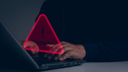 Businessman or programmer, developer, IT staff using computer laptop with triangle caution warning...