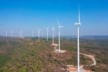 Aerial view of wind turbines or windmills farm field in industry factory. Power, sustainable green clean energy, and environment concept. Nature innovation.
