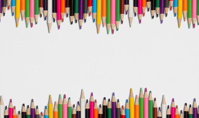 set of pencils of many colors on a white sheet of paper