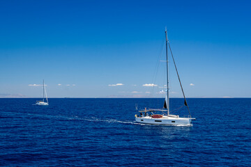 Fototapeta premium Two beautiful white sailing boats in the blue waters of the Mediterranean Sea