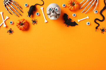 Happy Halloween holiday concept. Frame made of skull, bats, pumpkins, skeleton hands, snake, rat on orange background.