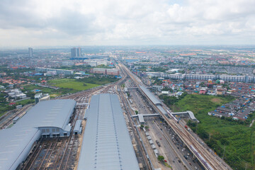 Aerial view of Bangkok Railway terminal station, BTS with skyscraper buildings in urban city, Bangkok downtown skyline, Thailand. Cars on traffic street road on highways.