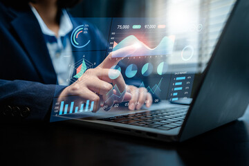 Businesswoman analyzes to chart data business on a visual screen dashboard, technology devices and screens visible in the background, financial planning, market research, and the stock market.