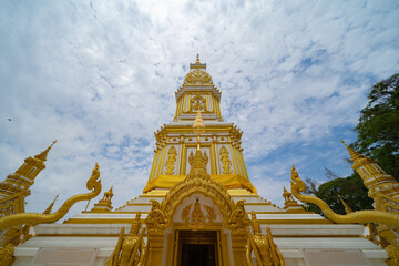 Fototapeta premium Wat Phrathat Phanom, Nakhon Phanom, Isan Temple. The pagoda is a buddhist temple in urban city town, Thailand. Thai architecture landscape background. Tourist attraction landmark.