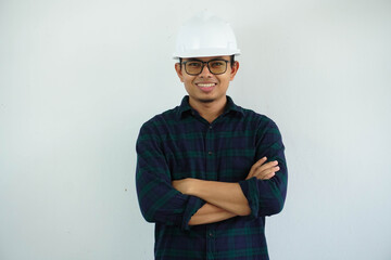 young asian man is engineer wearing helmet standing with crossed arms and smiling with confident, architect or contractor, worker or labor, industrial concept.