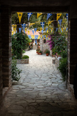 Fototapeta na wymiar Holy Monastery of the Annunciation to the Virgin Mary, view through an old gate and cobbled street