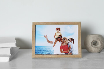 Obraz na płótnie Canvas Frame with family photo, books and other decor element on white wooden table indoors