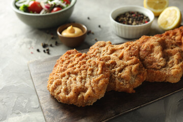 Tasty schnitzels served on grey table, closeup
