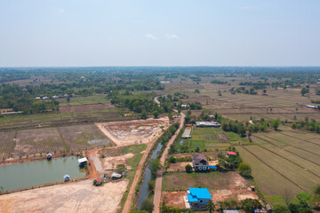 Aerial top view of fresh paddy rice, green agricultural fields in countryside or rural area in Asia, Thailand. Nature landscape