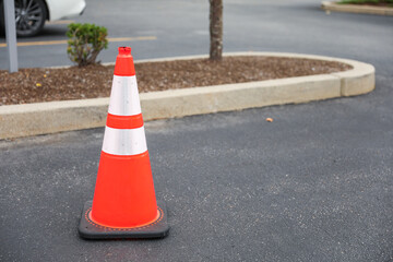 Orange cone on road symbolizes work in progress, caution, temporary disruption, safety measures and...