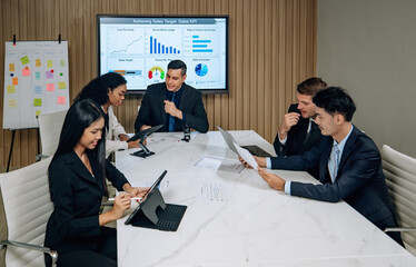 Diverse team innovates for sales KPIs via collaborative brainstorming to develop business models.